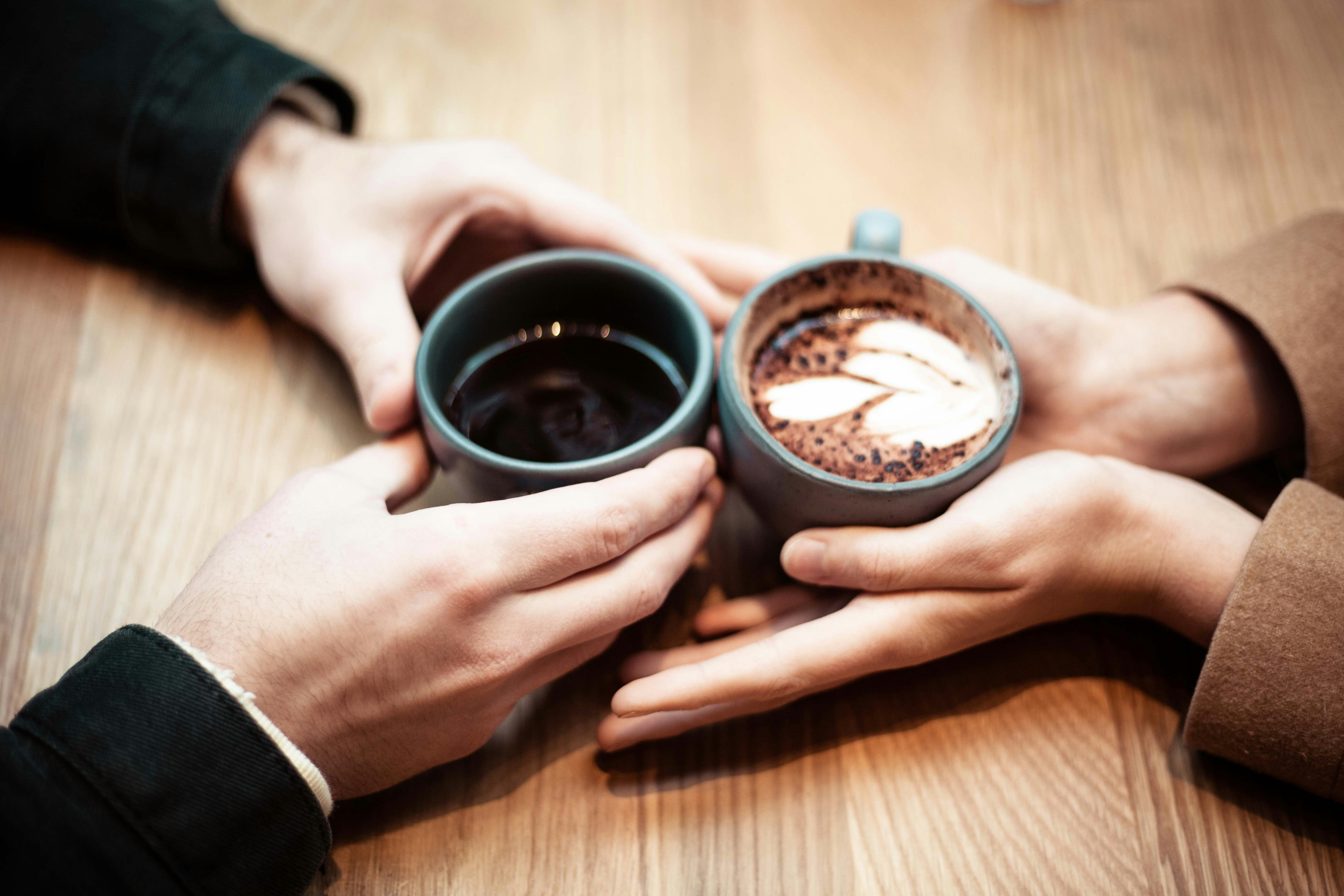 Two hands holding coffee cups