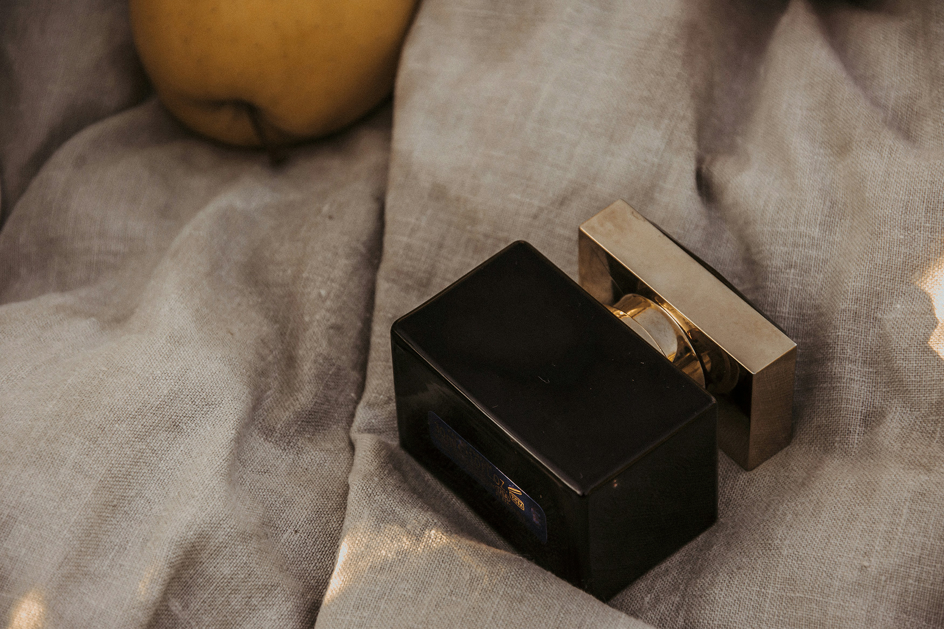 black qubic perfume bottle with a gold lid